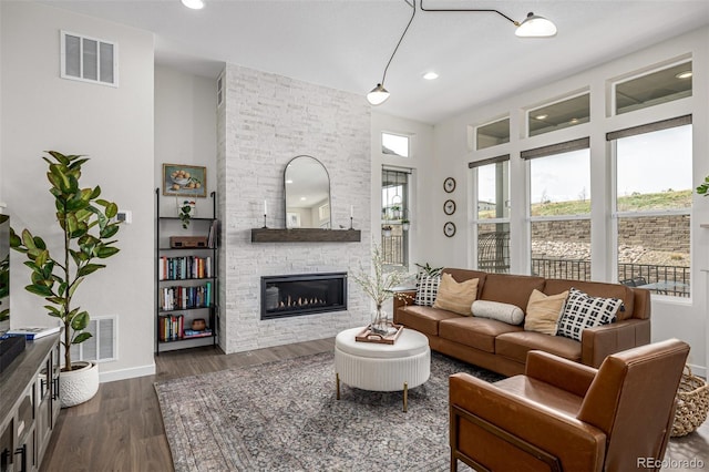 11027 Sunshimmer Cir, Parker, CO 80134 - living room featuring a stone fireplace, baseboards, dark wood-type flooring, and recessed lighting
