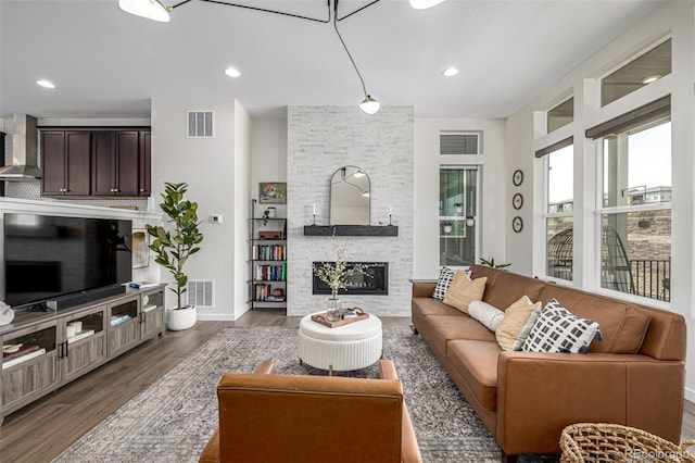 11027 Sunshimmer Cir, Parker, CO 80134 - living room featuring wood finished floors, a stone fireplace, baseboards, and recessed lighting