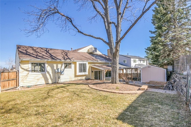 rear view of house with an outbuilding, a fenced backyard, a lawn, and a shed