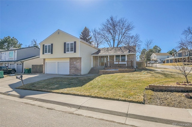 split level home with a front yard, fence, concrete driveway, a garage, and brick siding