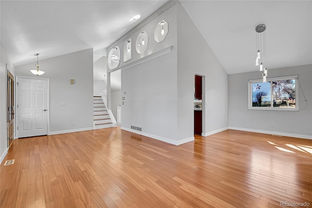 unfurnished living room with stairway, baseboards, visible vents, and light wood finished floors