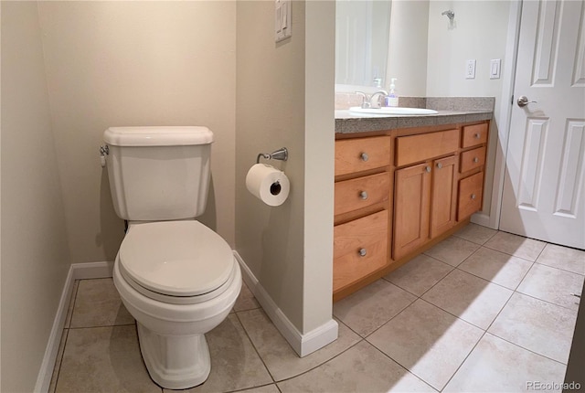 bathroom with vanity, toilet, baseboards, and tile patterned floors
