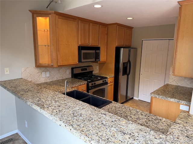 kitchen featuring baseboards, visible vents, a sink, tasteful backsplash, and appliances with stainless steel finishes