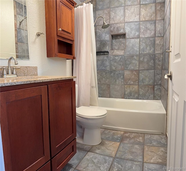 full bath with toilet, vanity, shower / bath combination with curtain, and stone finish floor