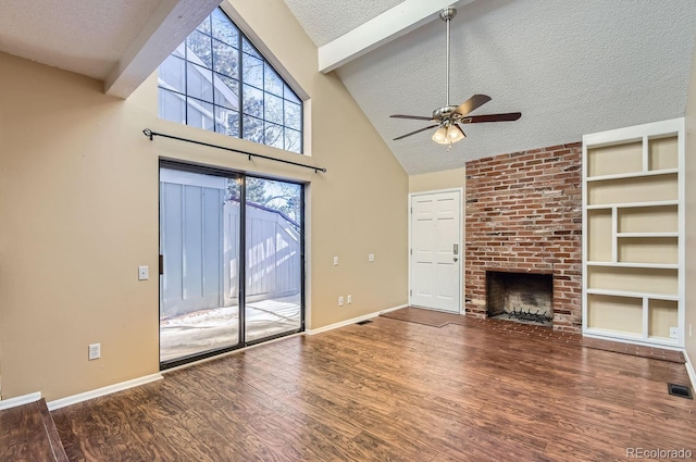 unfurnished living room with ceiling fan, a textured ceiling, a fireplace, beam ceiling, and wood-type flooring