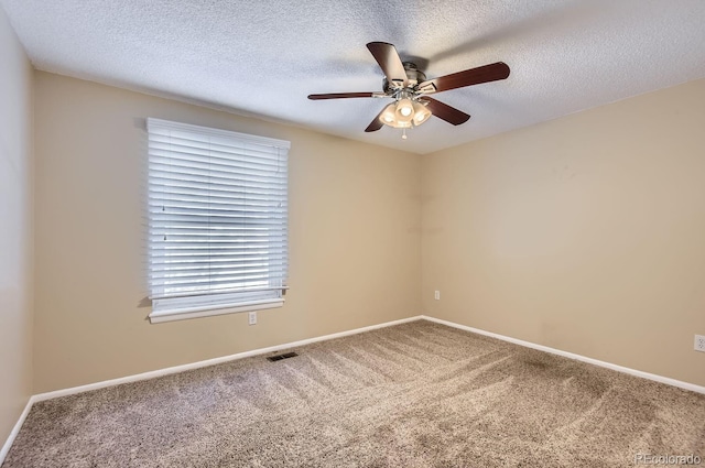 carpeted empty room featuring ceiling fan and a textured ceiling