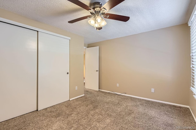 unfurnished bedroom featuring carpet flooring, ceiling fan, a textured ceiling, and a closet