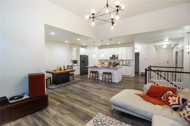 living room with dark hardwood / wood-style flooring, a high ceiling, and a chandelier