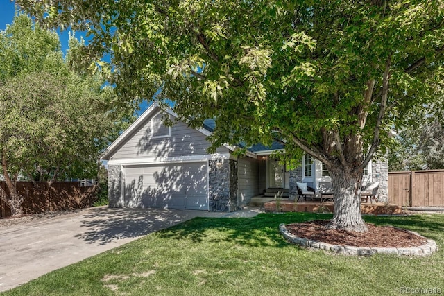 view of property hidden behind natural elements featuring a garage and a front lawn