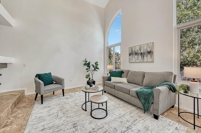 living area with a high ceiling and baseboards