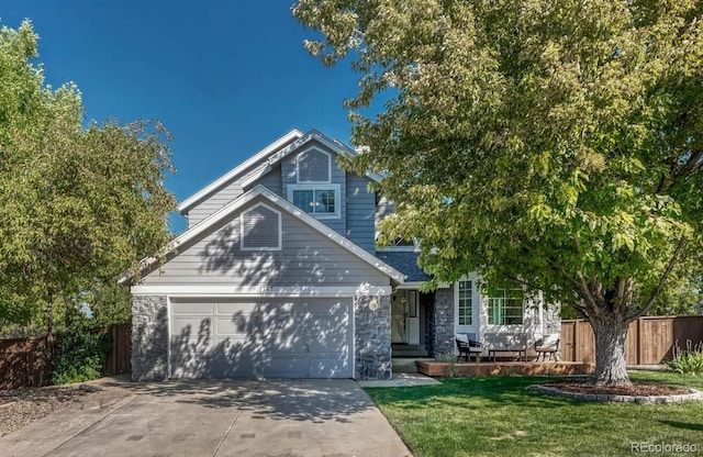 view of front of home featuring stone siding, fence, concrete driveway, a front yard, and an attached garage