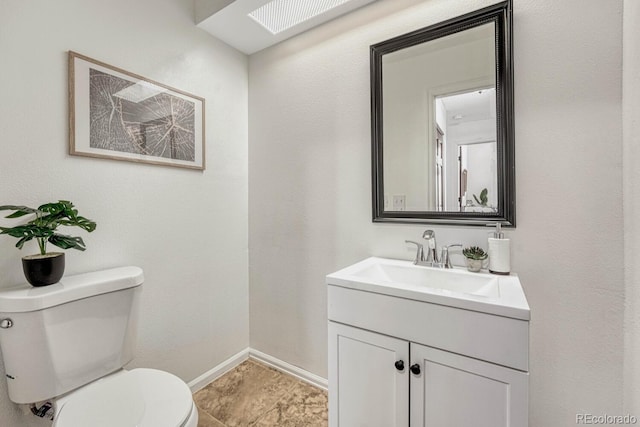 half bath with vanity, toilet, and baseboards