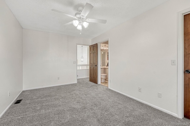 unfurnished bedroom featuring visible vents, connected bathroom, baseboards, carpet floors, and a textured ceiling