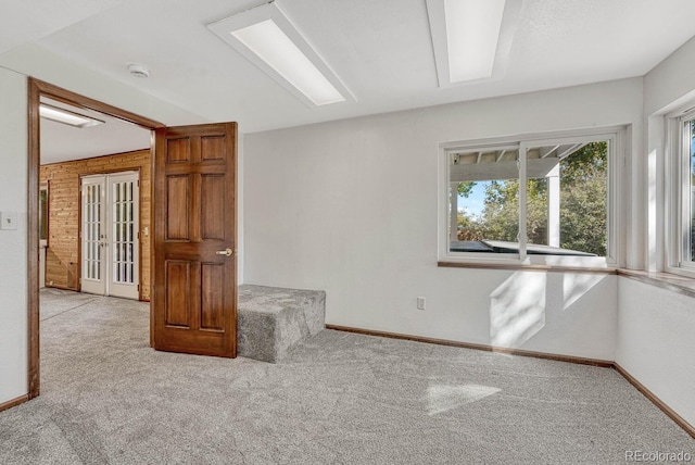 empty room featuring french doors, baseboards, and carpet floors