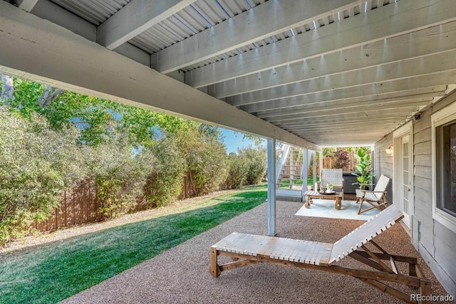 view of patio featuring stairs and fence