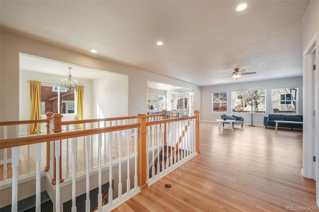 hallway with light hardwood / wood-style floors and a chandelier