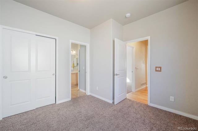 unfurnished bedroom featuring light colored carpet and a closet