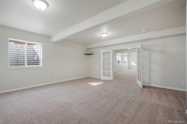 carpeted empty room with beam ceiling and french doors