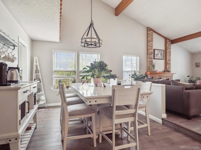 dining space featuring high vaulted ceiling, baseboards, beam ceiling, and wood finished floors