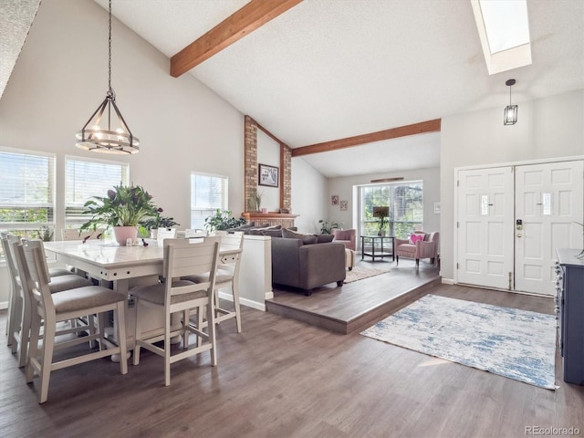 dining room with wood finished floors, beam ceiling, a notable chandelier, and high vaulted ceiling