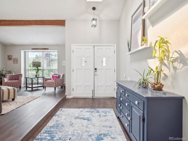 entrance foyer featuring beamed ceiling and dark wood-style floors