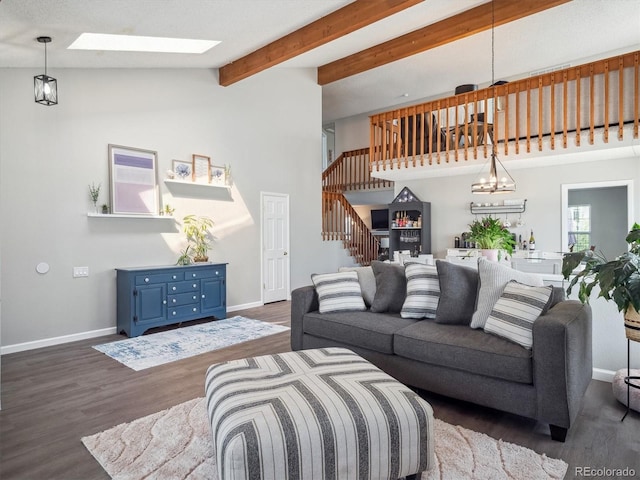 living room with stairs, wood finished floors, baseboards, lofted ceiling with skylight, and a chandelier
