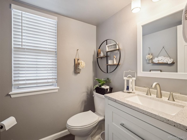 half bath featuring vanity and toilet