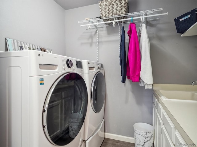 laundry area with baseboards, a sink, dark wood finished floors, and washer and dryer