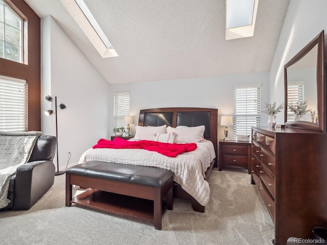 bedroom featuring a skylight, carpet floors, high vaulted ceiling, and a textured ceiling