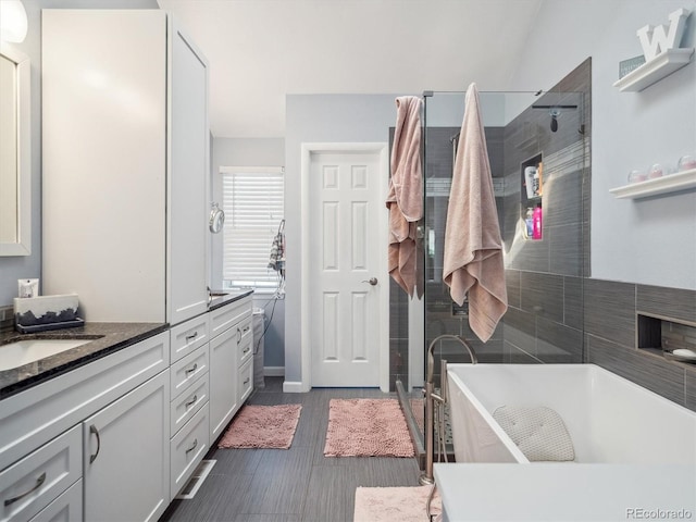 full bathroom with a freestanding bath, vanity, and a shower stall