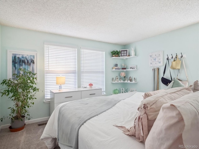 bedroom with baseboards, multiple windows, carpet flooring, and a textured ceiling