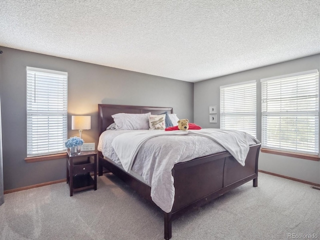 bedroom featuring baseboards, carpet, and a textured ceiling