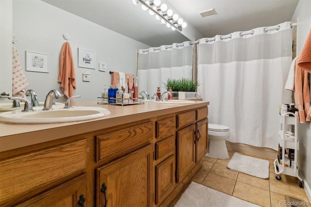 bathroom with visible vents, a sink, tile patterned flooring, and double vanity