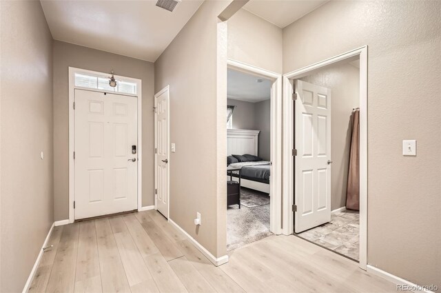 foyer entrance with light wood finished floors and baseboards