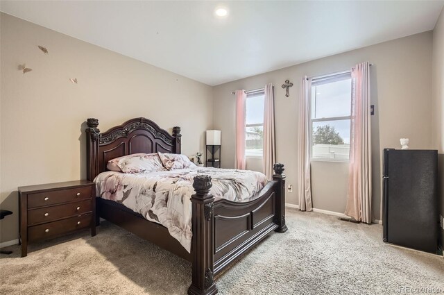 bedroom featuring light colored carpet and baseboards