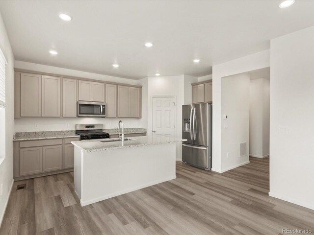 kitchen with recessed lighting, appliances with stainless steel finishes, wood finished floors, and a sink