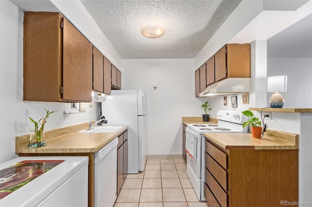381 S Ames St Unit B103, Lakewood, CO 80226 - kitchen featuring white appliances, under cabinet range hood, a textured ceiling, light tile patterned floors, and brown cabinetry