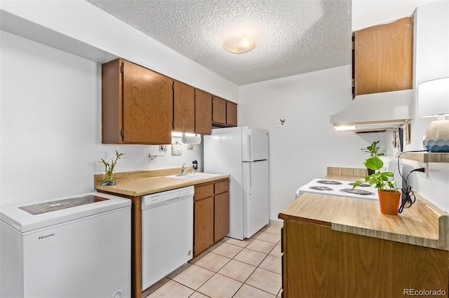 381 S Ames St Unit B103, Lakewood, CO 80226 - kitchen featuring white appliances, custom range hood, a textured ceiling, washer / clothes dryer, and light countertops