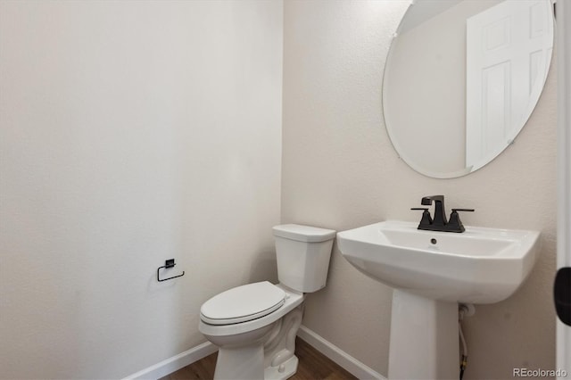 bathroom featuring toilet and wood-type flooring