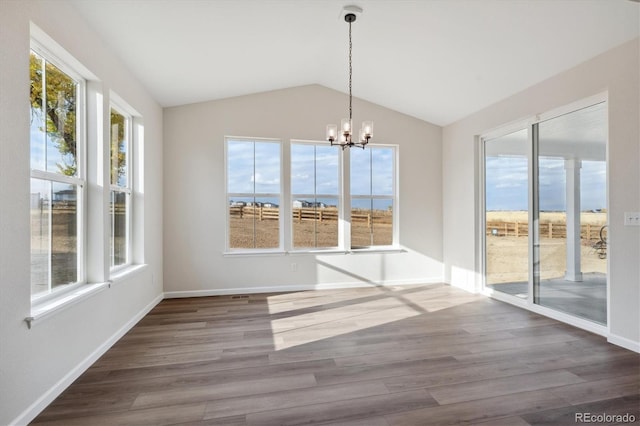 unfurnished dining area with a wealth of natural light, lofted ceiling, and dark hardwood / wood-style flooring