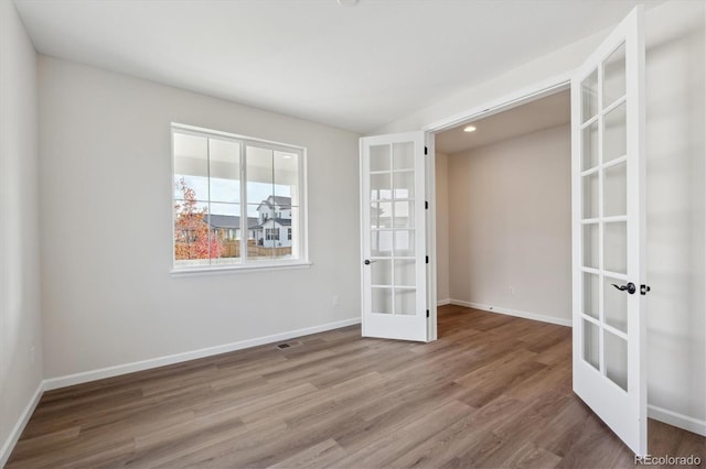 empty room featuring hardwood / wood-style floors and french doors