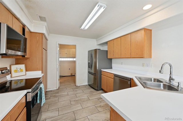 kitchen featuring visible vents, light countertops, appliances with stainless steel finishes, a peninsula, and a sink