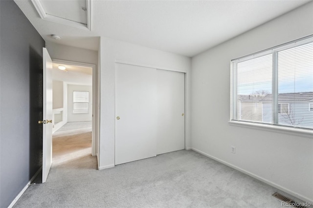 unfurnished bedroom with a closet, baseboards, and carpet floors