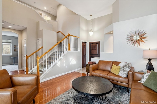 10358 Kelliwood Way, Highlands Ranch, CO 80126 - living area featuring a high ceiling, wood finished floors, baseboards, stairway, and arched walkways