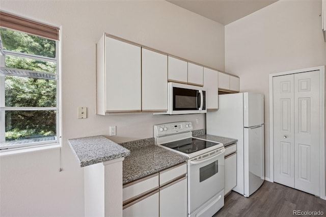 6087 Colony Cir, Colorado Springs, CO 80919 - kitchen with white appliances, white cabinets, dark wood finished floors, and plenty of natural light