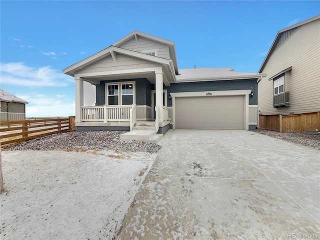 view of front of house with a garage, cooling unit, and covered porch