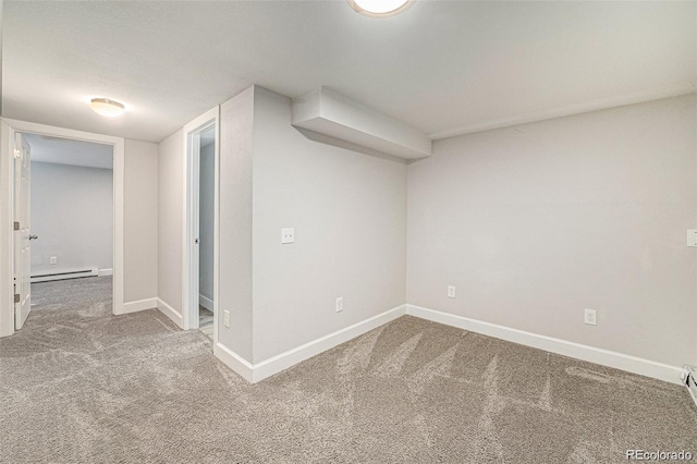 basement featuring a baseboard heating unit and carpet floors