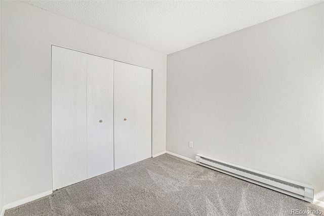 unfurnished bedroom featuring carpet, a baseboard radiator, a textured ceiling, and a closet