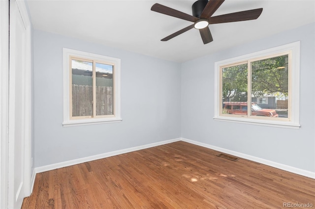 unfurnished room featuring ceiling fan, wood-type flooring, and plenty of natural light