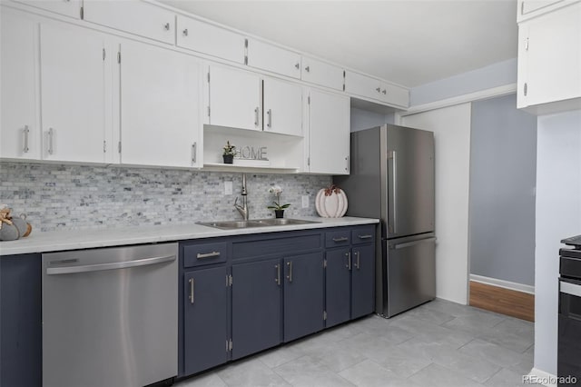 kitchen with white cabinetry, backsplash, stainless steel appliances, and blue cabinetry